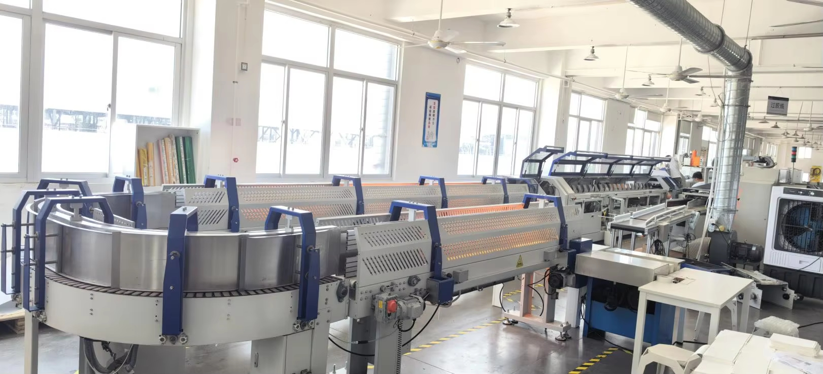 Book block back-gluing line in a stationery production facility