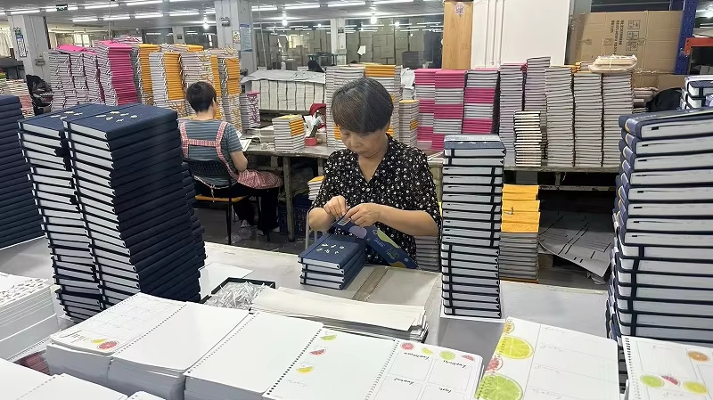 Production team checking finished notebooks before packing